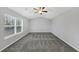 Inviting bedroom featuring a ceiling fan, large window, and plush gray carpeting at 5724 Antelope Trl, Atlanta, GA 30349