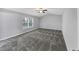 Spacious bedroom with a ceiling fan, large window, and plush gray carpeting at 5724 Antelope Trl, Atlanta, GA 30349