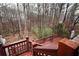 A red backyard deck provides a view of the property's wooded surroundings at 402 Rising Cir, Woodstock, GA 30189