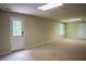 Bright, finished basement with neutral carpet, multiple windows, and an exterior door at 4569 Campenille Trce, Suwanee, GA 30024