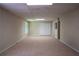Large finished basement with neutral carpet, recessed lighting, and multiple access doors at 4569 Campenille Trce, Suwanee, GA 30024