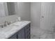 Modern bathroom features a stylish vanity with marble countertop and tiled floors at 4569 Campenille Trce, Suwanee, GA 30024