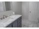 Updated bathroom with navy vanity, marble countertop, and tiled floor at 4569 Campenille Trce, Suwanee, GA 30024