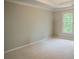 Empty bedroom with light carpet and trim, featuring a trey ceiling, and a large window at 4569 Campenille Trce, Suwanee, GA 30024