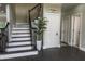Inviting foyer showcasing a staircase with dark wood steps, a black railing, and stylish gray walls at 4569 Campenille Trce, Suwanee, GA 30024