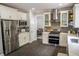 Well-lit kitchen featuring stainless steel appliances, white cabinetry, and stone countertops at 4569 Campenille Trce, Suwanee, GA 30024