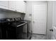 Well-lit laundry room with modern washer and dryer units, storage, and tile floors at 4569 Campenille Trce, Suwanee, GA 30024
