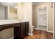 Bathroom vanity with dark wood cabinets and a walk-in closet at , Fairburn, GA 30213