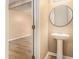 Powder room featuring a pedestal sink, round mirror, and neutral wall paint, offering a minimalist and clean design at , Fairburn, GA 30213