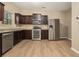 Modern kitchen with stainless steel appliances, granite countertops, dark wood cabinets and sleek light wood flooring at , Fairburn, GA 30213