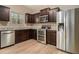 Well-equipped kitchen with stainless steel appliances, granite countertops, dark wood cabinets, and stylish light wood flooring at , Fairburn, GA 30213