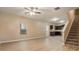 Open-concept layout with light wood floors, seamlessly connecting living area to kitchen and staircase. Features a ceiling fan and natural light at , Fairburn, GA 30213