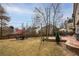 Backyard showcasing a patio area with outdoor seating, mature trees, and a lush green lawn at 1219 Hadaway Ct, Lawrenceville, GA 30043