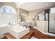 Elegant bathroom featuring a soaking tub, a walk-in shower, and a large window for natural light at 1219 Hadaway Ct, Lawrenceville, GA 30043