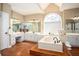 Luxurious bathroom with a large soaking tub, double vanity, and an arched window at 1219 Hadaway Ct, Lawrenceville, GA 30043