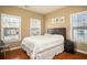 Comfortable bedroom featuring hardwood floors, three windows, and a double bed at 1219 Hadaway Ct, Lawrenceville, GA 30043