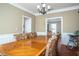 Dining room featuring a large table, wainscoting, chandelier, and views to the kitchen at 1219 Hadaway Ct, Lawrenceville, GA 30043