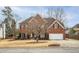 Attractive brick home with a two-car garage, a manicured lawn, and mature trees in a suburban setting at 1219 Hadaway Ct, Lawrenceville, GA 30043
