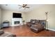 Cozy living room featuring a fireplace, comfortable leather seating, and a ceiling fan at 1219 Hadaway Ct, Lawrenceville, GA 30043