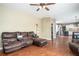 Open-concept living room with a leather sectional, wood floors, and views into the kitchen at 1219 Hadaway Ct, Lawrenceville, GA 30043