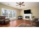 Spacious living room featuring a fireplace, large windows, and comfortable leather furniture at 1219 Hadaway Ct, Lawrenceville, GA 30043