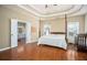 Spacious main bedroom with hardwood floors, a four-poster bed, and an ensuite bathroom at 1219 Hadaway Ct, Lawrenceville, GA 30043