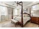 This primary bedroom features a four-poster bed, an area rug, and two windows with flowing white curtains at 15 Lakeside Way, Cartersville, GA 30121