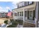Charming front porch with stone steps, white railings, an American flag, and a light blue front door at 15 Lakeside Way, Cartersville, GA 30121
