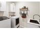 Functional laundry room featuring modern appliances, storage cabinets, and a stylish patterned floor at 15 Lakeside Way, Cartersville, GA 30121