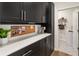 Well-organized mudroom with sleek black cabinets, a white countertop, and access to the laundry room at 15 Lakeside Way, Cartersville, GA 30121
