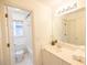 Bright bathroom with white cabinets, sink, and mirror, and a view of the tub and toilet at 200 Ridge Bluff Ln, Suwanee, GA 30024