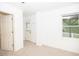 Bright bedroom features neutral carpeting and white walls, with a window and two entry doors at 200 Ridge Bluff Ln, Suwanee, GA 30024