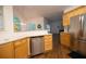 Open kitchen with wood cabinets, stainless steel dishwasher and refrigerator, with a breakfast bar at 200 Ridge Bluff Ln, Suwanee, GA 30024