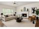 Cozy living room with neutral decor, fireplace, ceiling fan, and natural light at 200 Ridge Bluff Ln, Suwanee, GA 30024