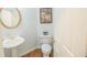 Cozy powder room featuring a pedestal sink with gold fixtures and an ornate, round mirror at 200 Ridge Bluff Ln, Suwanee, GA 30024