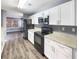 Modern kitchen with granite counters, white cabinets, and black appliances at 453 Inkberry Dr, Atlanta, GA 30349