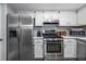 Updated kitchen featuring stainless steel appliances, white cabinetry, and a functional layout at 101 Fair Haven Se Way, Smyrna, GA 30080