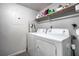 Functional laundry room featuring a washer, dryer, and shelving for storage at 101 Fair Haven Se Way, Smyrna, GA 30080