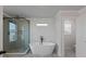 Bright bathroom features a glass shower, tub, geometric wall design and grey flooring at 4024 Hosch Retreat Dr, Buford, GA 30519