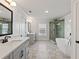 Bright bathroom features dual vanities, stylish mirrors, and an en suite glass shower and tub at 4024 Hosch Retreat Dr, Buford, GA 30519