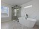Bright bathroom features a glass shower, soaking tub, and a modern elegant design at 4024 Hosch Retreat Dr, Buford, GA 30519