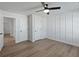 Modern bedroom with light hardwood flooring, wainscoting, and a ceiling fan at 4024 Hosch Retreat Dr, Buford, GA 30519