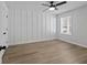 Bright bedroom featuring hardwood floors, a modern ceiling fan, and wainscoting at 4024 Hosch Retreat Dr, Buford, GA 30519