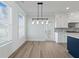 Bright dining room with large windows, modern lighting fixture, and wood floors at 4024 Hosch Retreat Dr, Buford, GA 30519