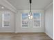 Light-filled dining room with modern light fixture and large windows, showcasing the bright and airy ambiance at 4024 Hosch Retreat Dr, Buford, GA 30519