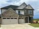 Two-story home with a three-car garage, brick and siding exterior, and well-maintained landscaping at 4024 Hosch Retreat Dr, Buford, GA 30519