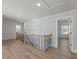 Bright hallway with light hardwood floors, modern railing, and access to other rooms at 4024 Hosch Retreat Dr, Buford, GA 30519