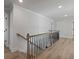 Bright hallway with light hardwood floors and modern railing showcases open floor plan at 4024 Hosch Retreat Dr, Buford, GA 30519