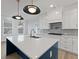 Modern kitchen island featuring a white countertop, blue base, and stylish pendant lighting above at 4024 Hosch Retreat Dr, Buford, GA 30519