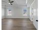 Spacious main bedroom with tray ceiling, light hardwood floors and two windows at 4024 Hosch Retreat Dr, Buford, GA 30519